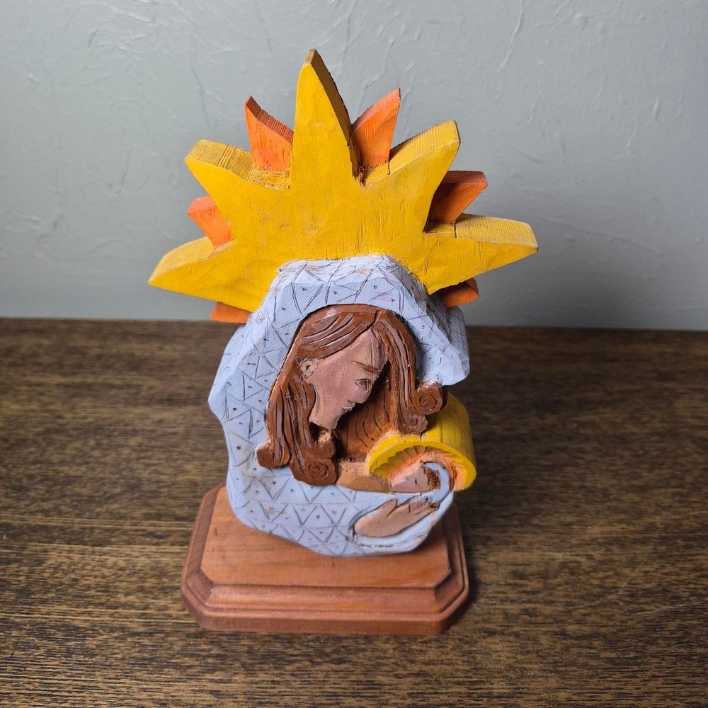 Hand carved wooden nativity scene with Mary holding baby Jesus